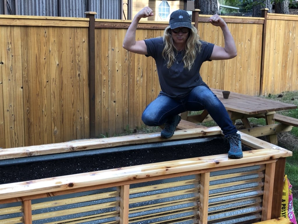 girl on a raised garden box 