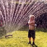 kid playing with a sprinkler