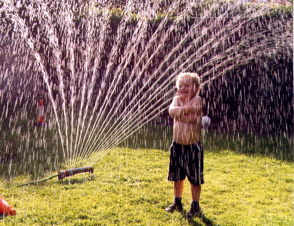 kid playing with a sprinkler