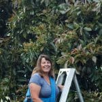 Anne Carter on her farm on a ladder